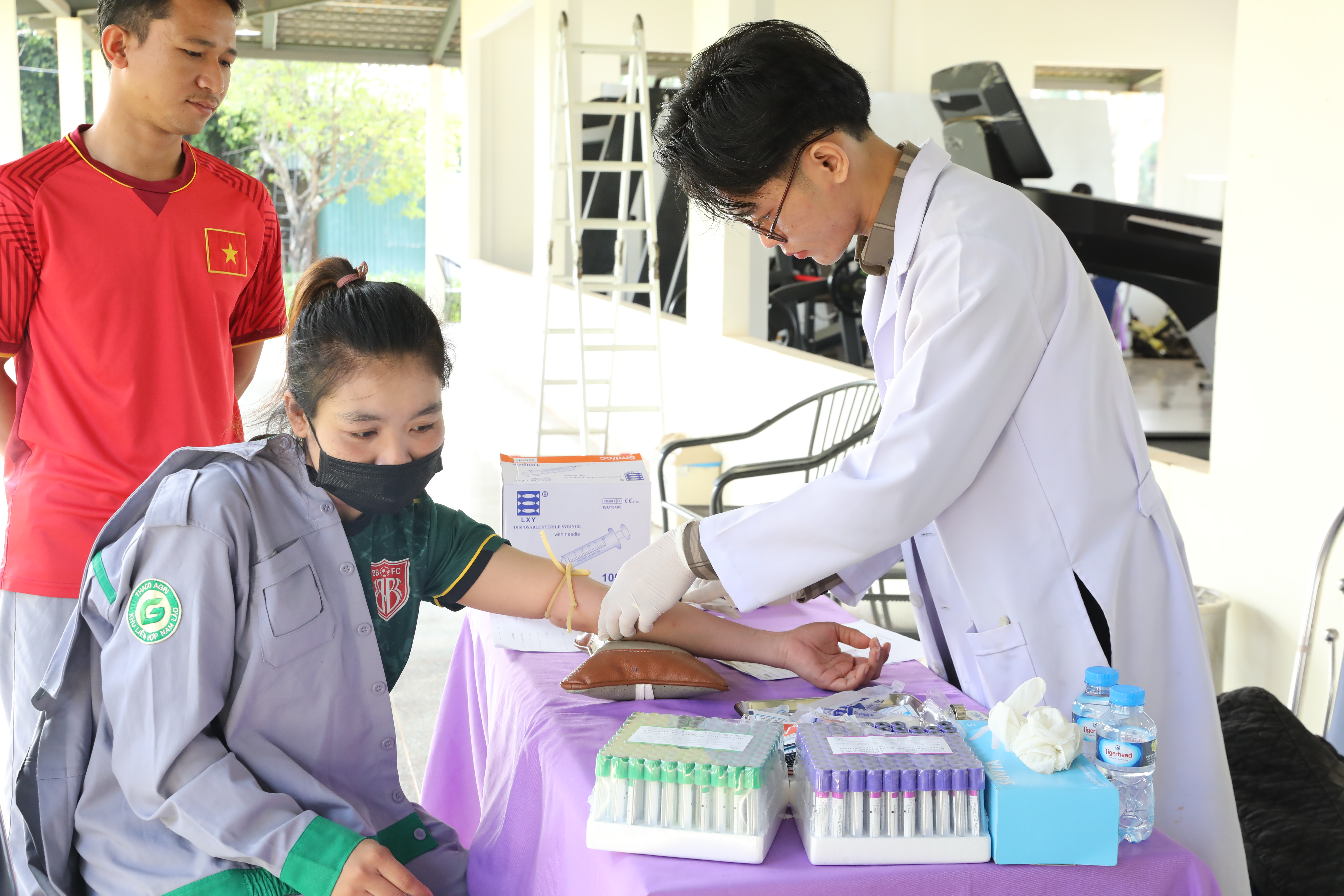 Bác sĩ thực hiện kiểm tra sức khỏe cho công nhân theo quy trình.